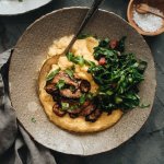 Vegan cheese grits in a bowl with greens