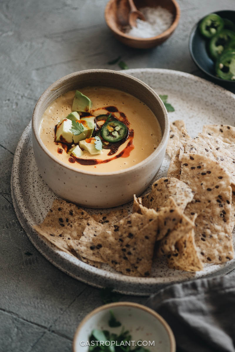Vegan cheesy queso dip in a bowl with tortilla chips