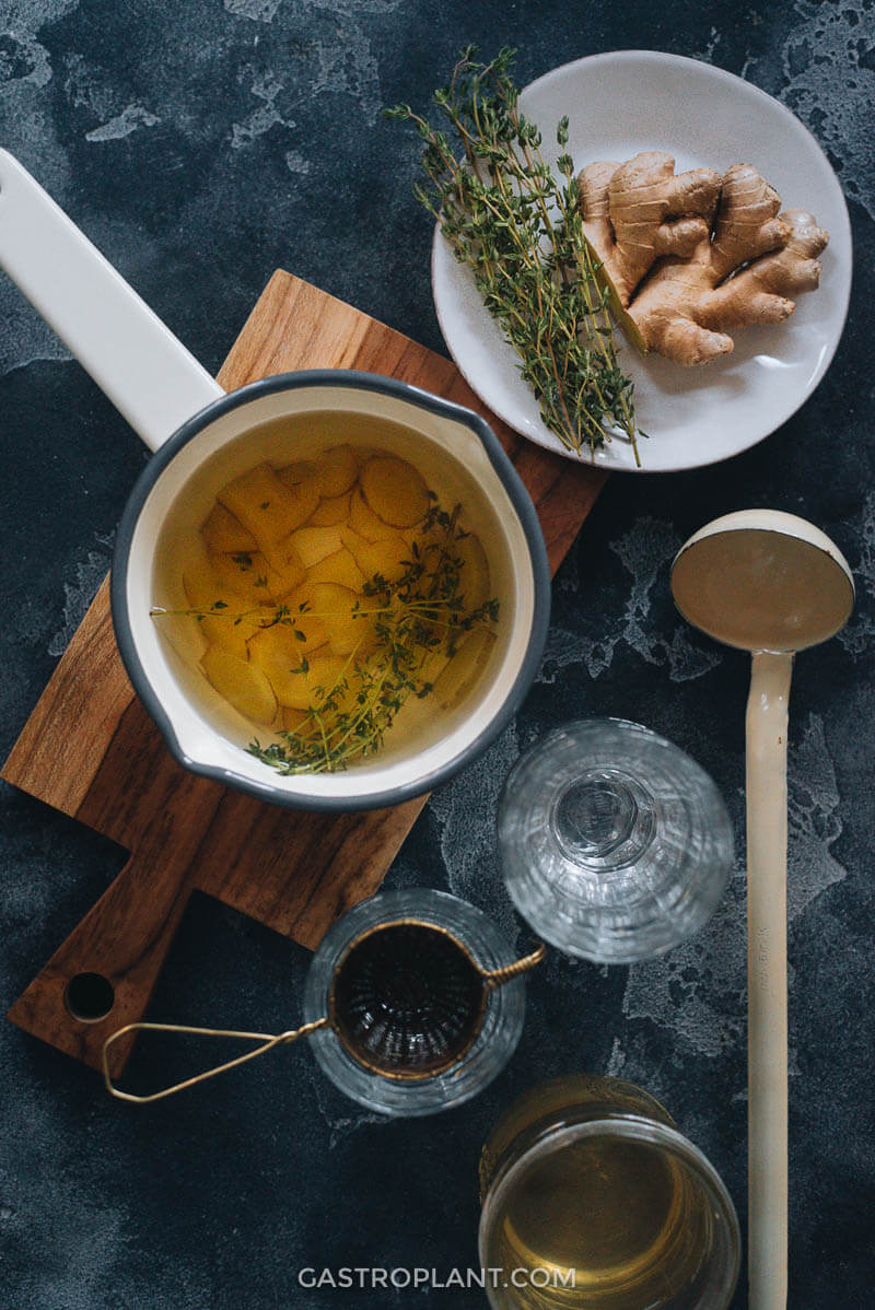 Ginger thyme tea in a pot with ingredients on the side
