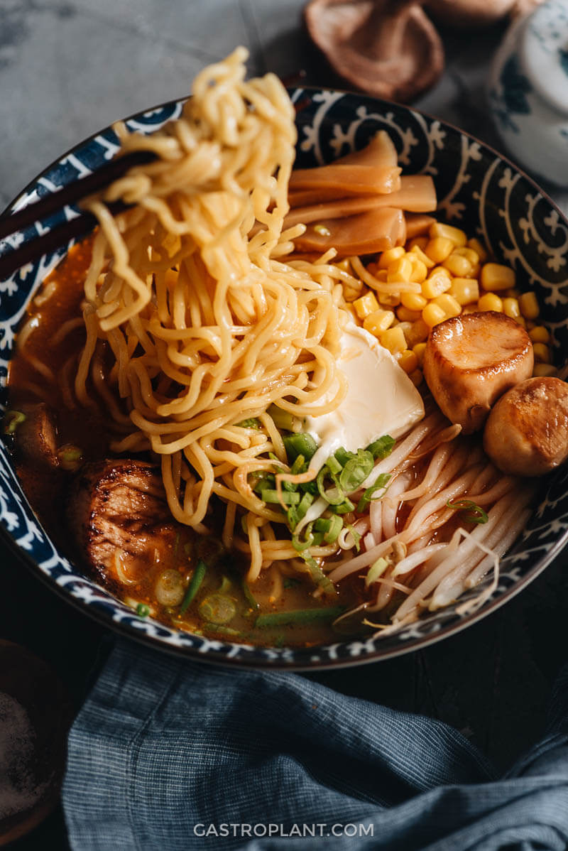 Close up of vegan miso ramen noodle soup with corn, bamboo, king oyster mushrooms, and bean sprouts