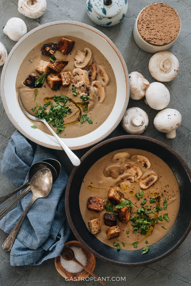 Two bowls of vegan cream of mushroom soup with croutons