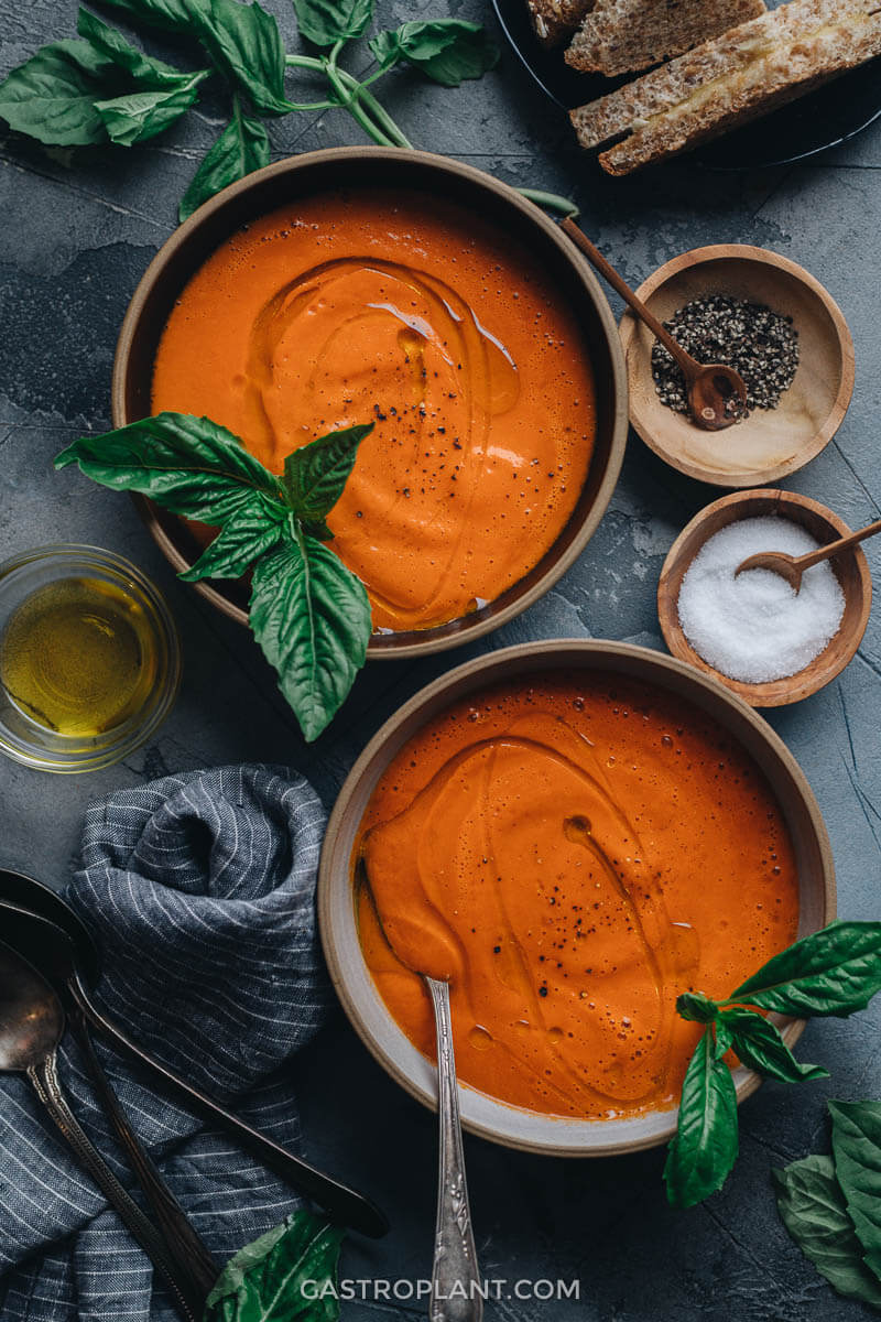 Two bowls of easy creamy vegan tomato soup with basil