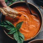 Dipping vegan grilled cheese into creamy homemade tomato soup