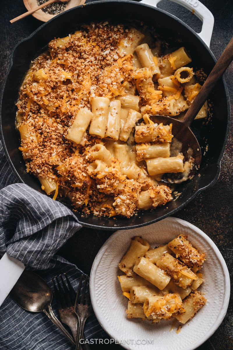 Creamy baked vegan mac and cheese in a skillet and bowl