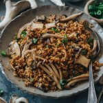 A bowl of fried rice with lots of mushrooms and a spoon