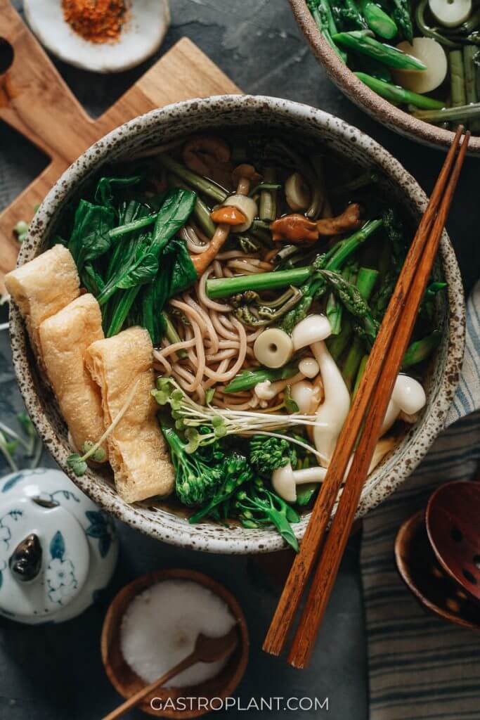 A bowl of vegan sansai soba noodle soup with crispy tofu