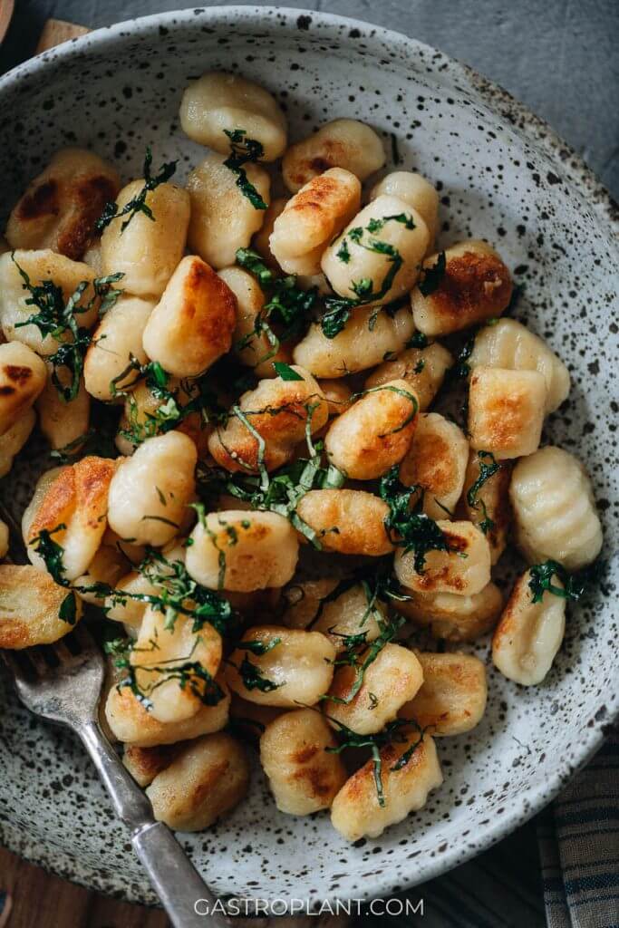 Close up of vegan potato gnocchi sauteed with herbs