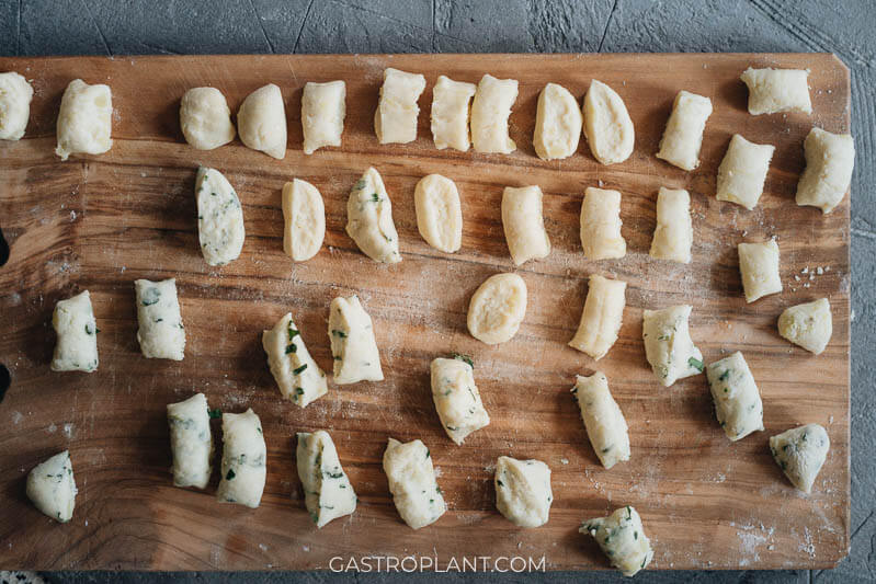 Freshly cut potato gnocchi on a wooden cutting board