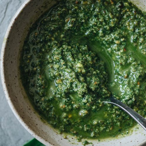 A bowl of bright green vegan basil pesto