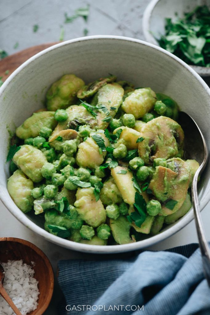 Bright, fresh green pea pasta sauce on gnocchi with peas and mushrooms