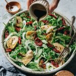 Pouring oil and vinegar dressing onto fennel salad