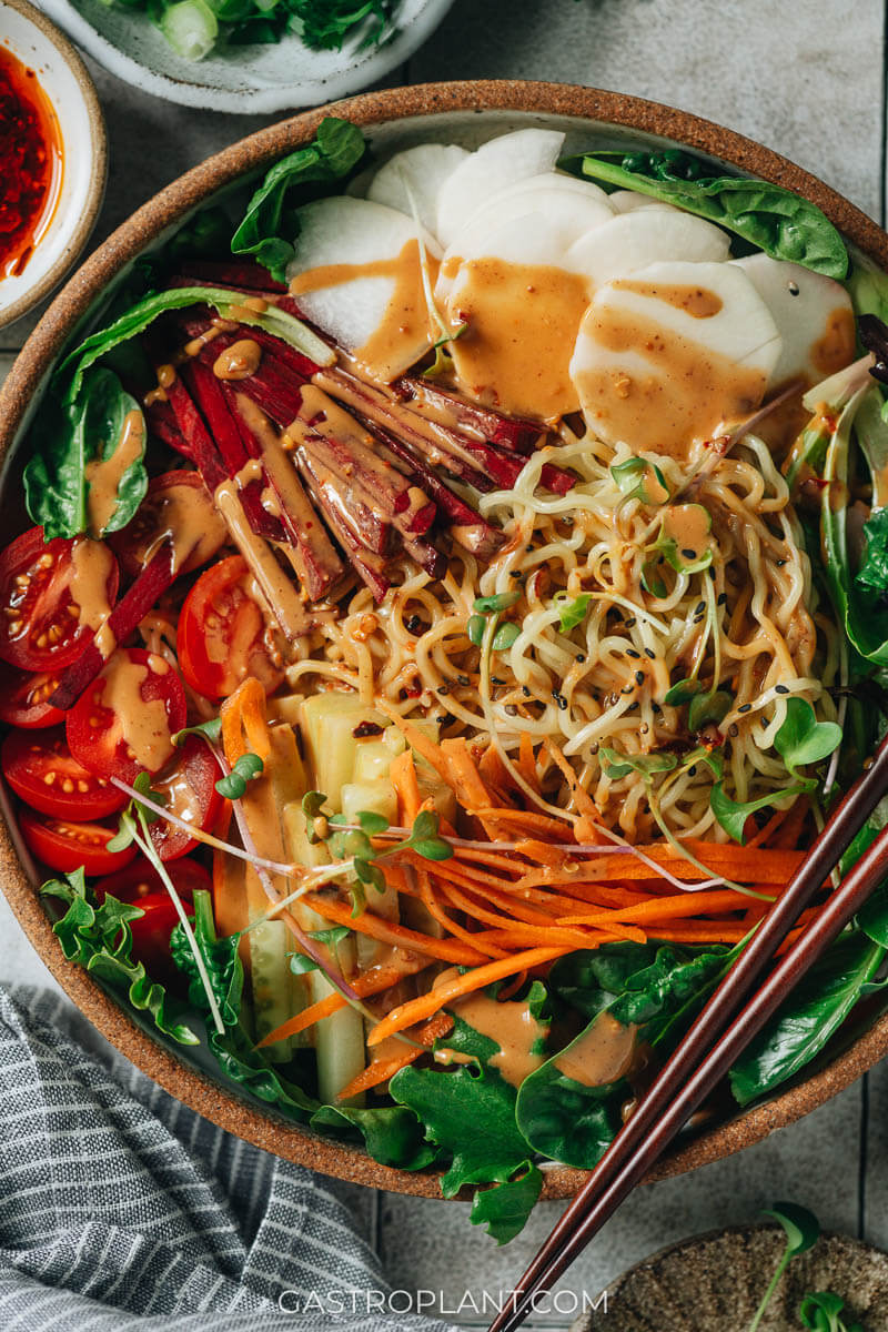 A bowl of noodles and colorful veggies with sesame sauce (vegan)