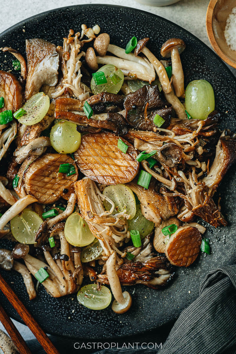 Close-up photo of various wild mushrooms pan-roasted with green onions